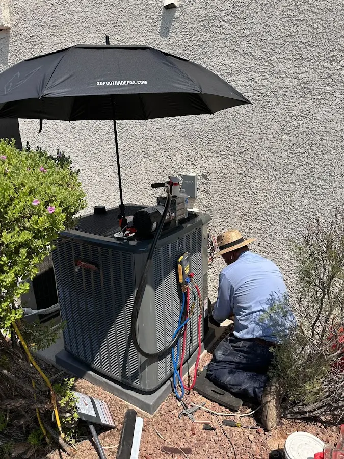HVAC technician performing outdoor AC maintenance in Caldwell