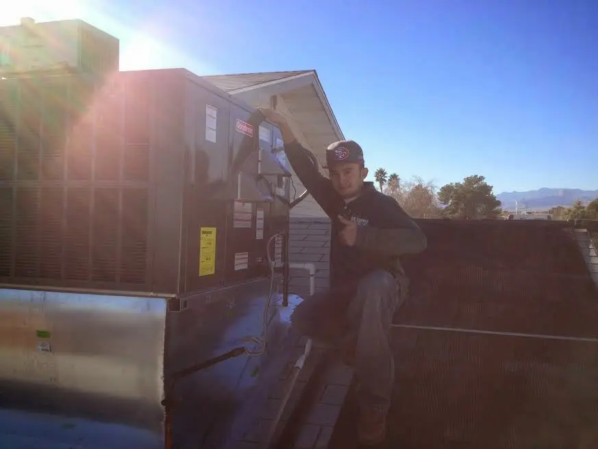 HVAC technician performing HVAC Inspection on a rooftop unit in Caldwell